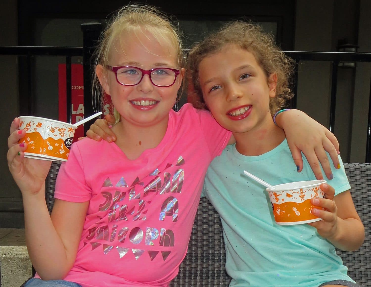 Two Crystal Challenges students sharing snow cones, arms around each other.