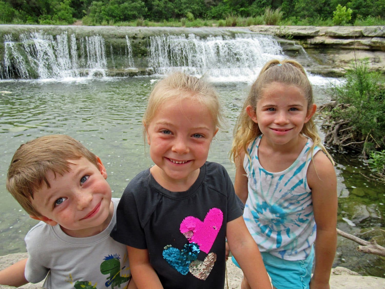 Three Crystal Challenges students standing together in front of a waterfall on a hike.